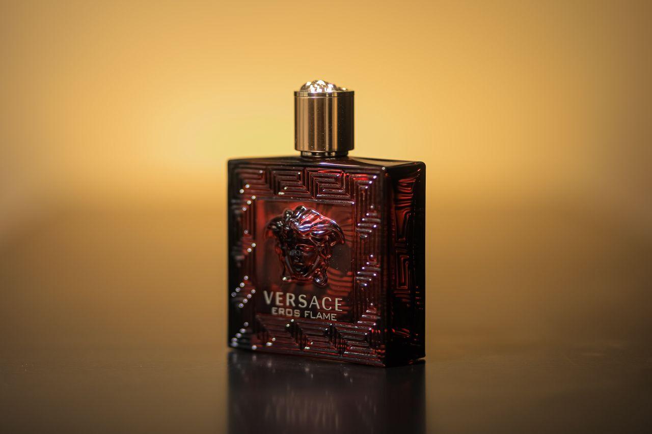 cta-01 Close-up of Versace Eros Flame perfume bottle with a warm yellow backdrop.